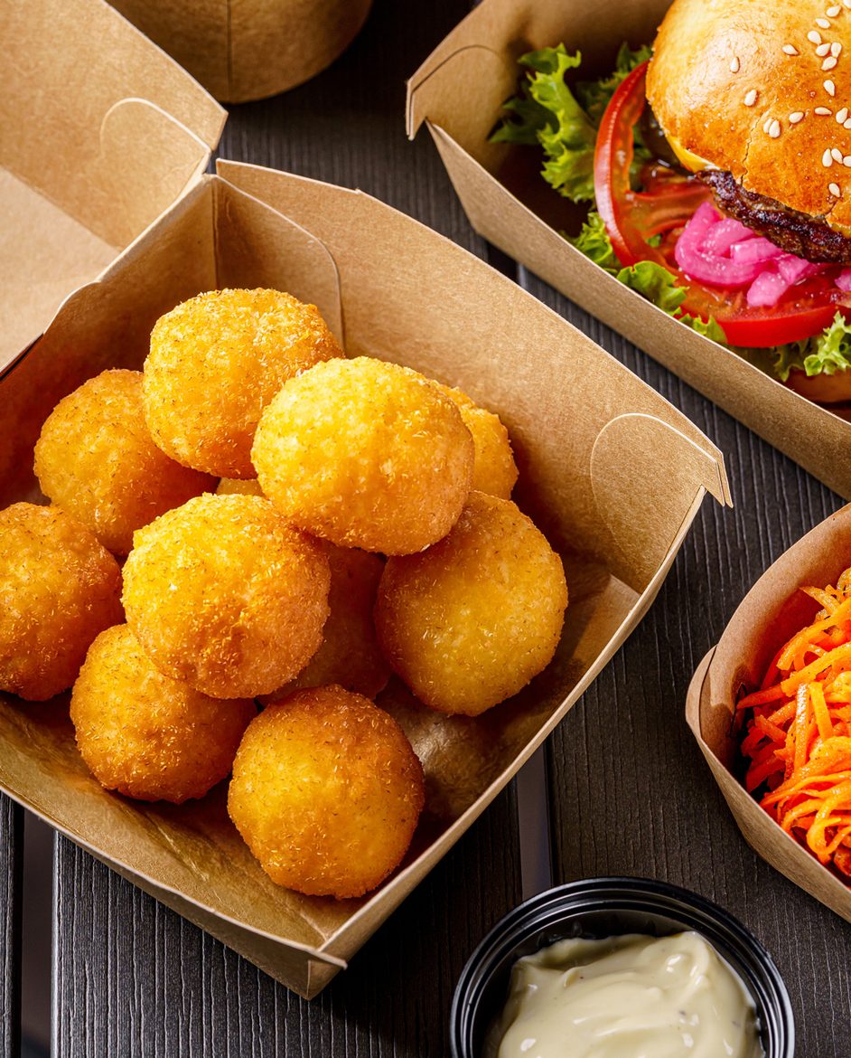 Crumbed cheese bites in a QSR carton, with a burger